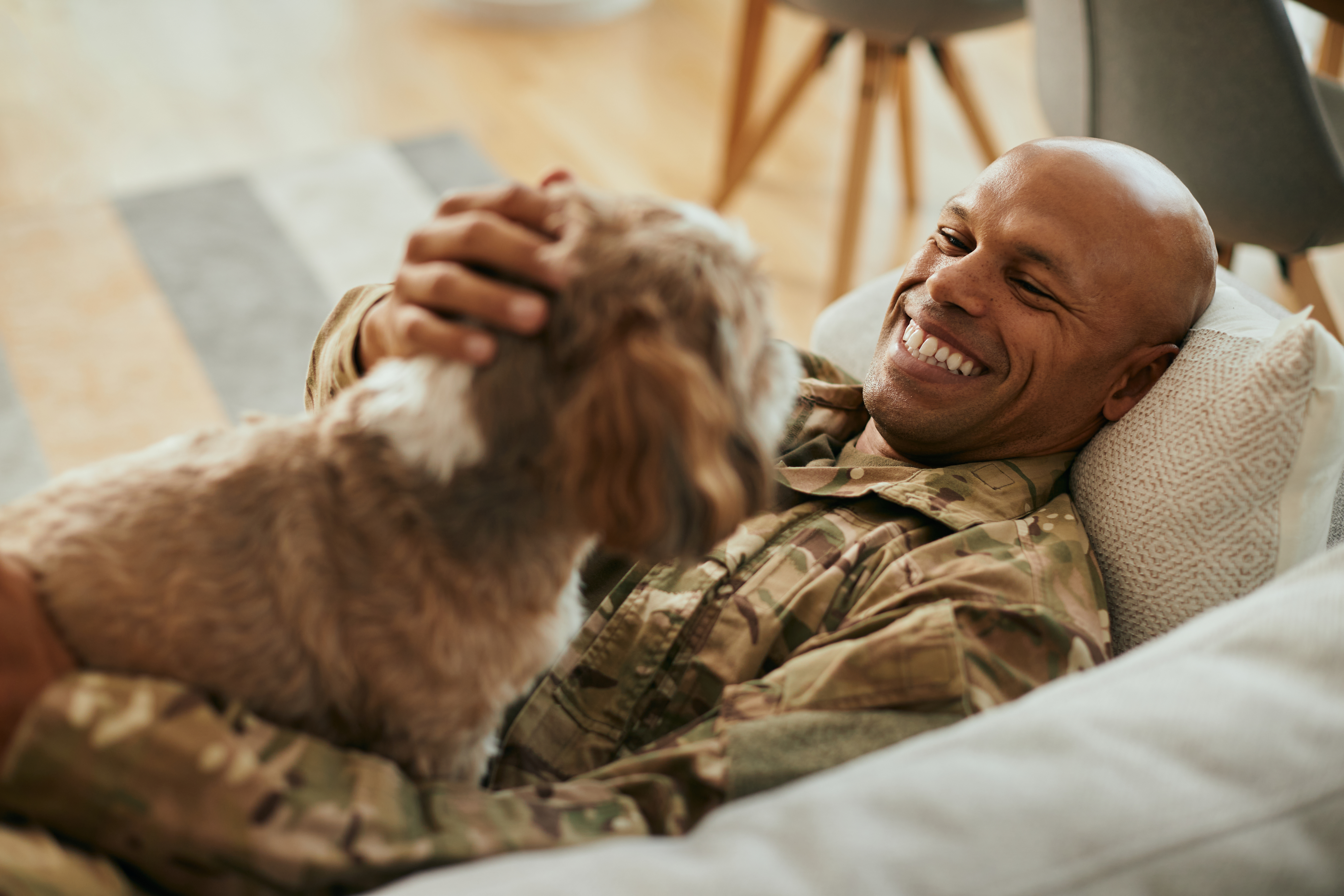 Veteran or military-connected pet caregiver relaxing with a dog